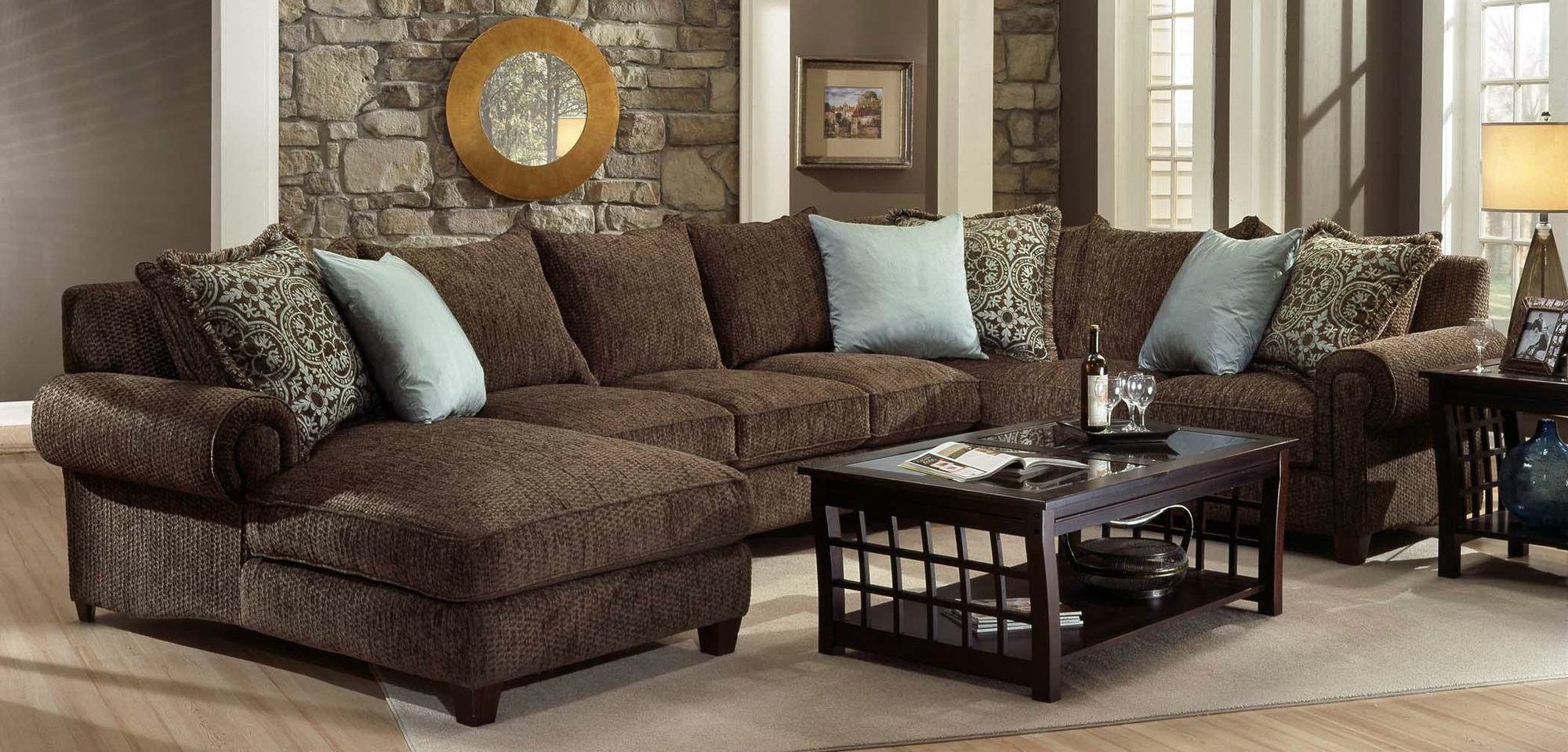 Brown sectional sofa with blue and patterned pillows in a living room
